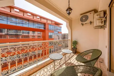 a balcony with chairs and tables and a window at Modern Haven Guéliz, Netflix, Comfort in Marrakech