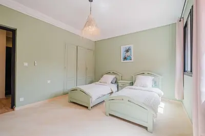 two beds in a room with white walls at Charmant appartement lumineux pres de Gueliz. in Marrakech