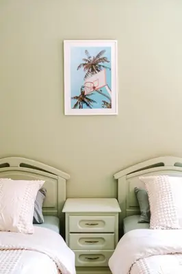 a bedroom with two beds and a picture on the wall at Charmant appartement lumineux pres de Gueliz. in Marrakech