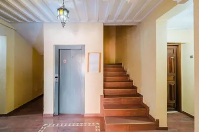 a hallway with stairs and a blue door at Charmant appartement lumineux pres de Gueliz. in Marrakech