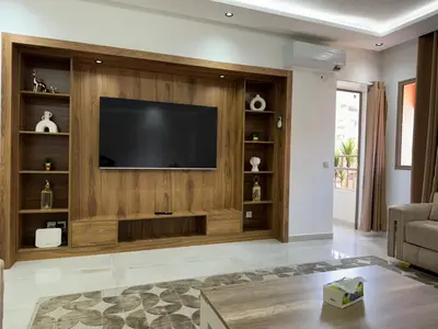 a living room with a flat screen tv on a wooden wall at Duplex Menara Mall in Marrakech