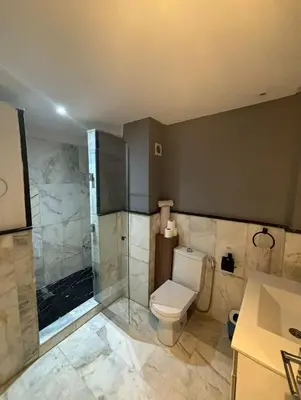 a bathroom with a toilet and a glass shower at Studio Centre Ville in Marrakech
