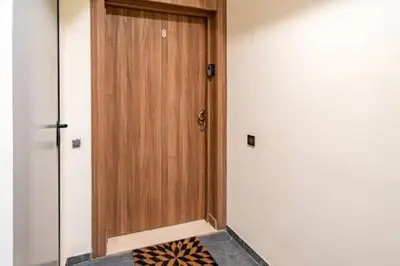 a wooden door in a room with a rug at Emplacement idéal fraîcheur garantie, piscine netflix in Marrakech