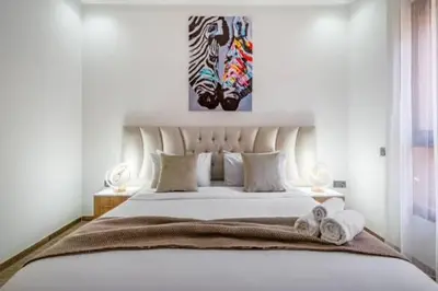 a bedroom with a large white bed with towels on it at Emplacement idéal fraîcheur garantie, piscine netflix in Marrakech