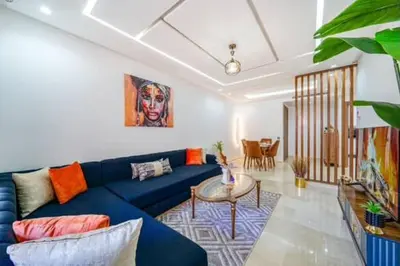 a living room with a blue couch and a table at Emplacement idéal fraîcheur garantie, piscine netflix in Marrakech