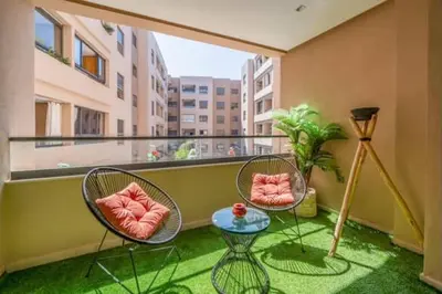 a balcony with two chairs and a table and a lamp at Emplacement idéal fraîcheur garantie, piscine netflix in Marrakech