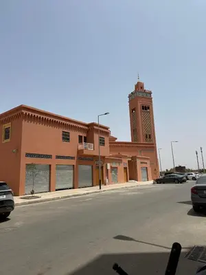 a large building with a clock tower on a street at Appartement 2 chambre cosy in Marrakech