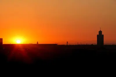 a sunset over a city with a silhouette of a building at apartment,5 min to airport, In a quiet place in Marrakech