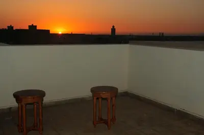 two stools sitting next to a wall with the sunset at apartment,5 min to airport, In a quiet place in Marrakech