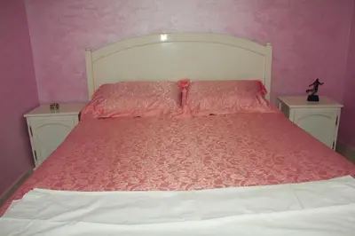 a pink bedroom with a bed with two night stands at apartment,5 min to airport, In a quiet place in Marrakech