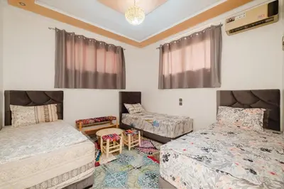 a bedroom with two beds and a chandelier at Aéroport hostel et chambre appartement studio Marrakech in Marrakech