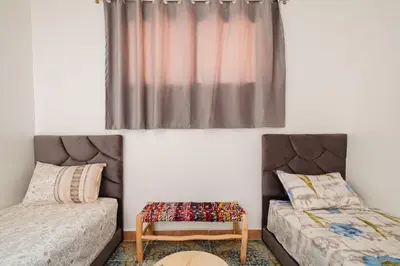 a bedroom with two beds and a window at Aéroport hostel et chambre appartement studio Marrakech in Marrakech