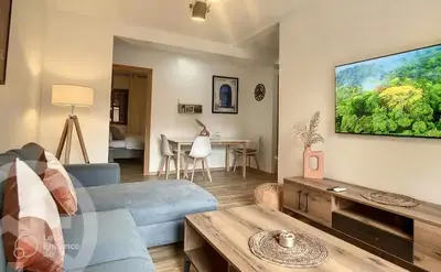 a living room with a couch and a tv on a wall at Apartments giliz Marrakech in Marrakech