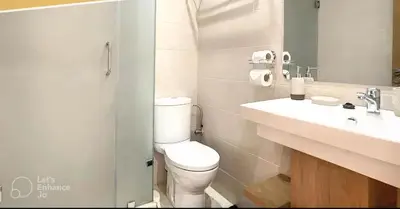 a white bathroom with a toilet and a sink at Apartments giliz Marrakech in Marrakech