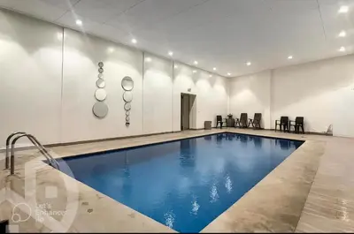 a swimming pool in a white room with a blue pool at Apartments giliz Marrakech in Marrakech