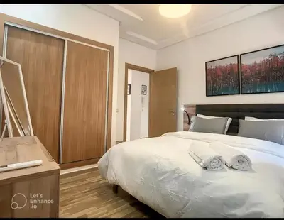 a bedroom with a large white bed with two pillows at Apartments giliz Marrakech in Marrakech