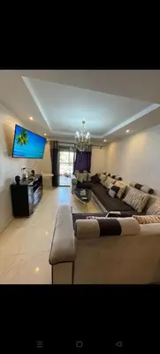 a living room with a couch and a flat screen tv at Location haut standing au cœur de Marrakech in Marrakech