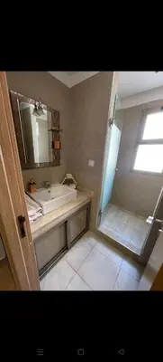 a bathroom with a sink and a shower with a mirror at Location haut standing au cœur de Marrakech in Marrakech