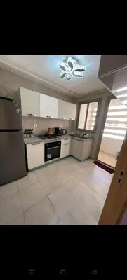 a large kitchen with white appliances and a ceiling at Location haut standing au cœur de Marrakech in Marrakech