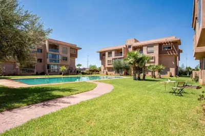 a resort with a swimming pool and a building at Location haut standing au cœur de Marrakech in Marrakech