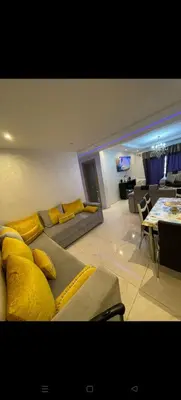 a living room with yellow pillows on a couch at Location haut standing au cœur de Marrakech in Marrakech