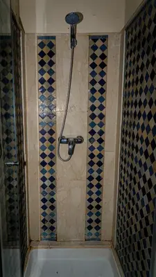 a bathroom with a shower with blue and black tiles at Appartement 2 bedroom Babylone center in Marrakech
