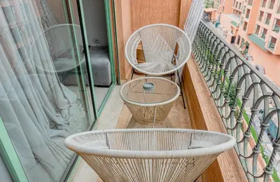 a balcony with two tables and chairs on a balcony at Appartement 2 bedroom Babylone center in Marrakech