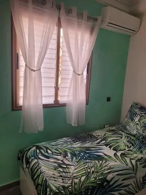 a bedroom with a bed and a window with curtains at Au cœur de l orient Marrakech in Marrakech