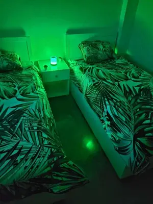 two beds in a dark room with green lights at Au cœur de l orient Marrakech in Marrakech