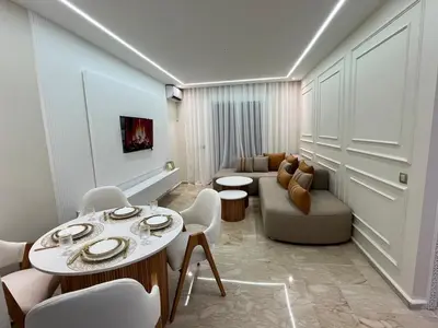 a living room with a couch and a table and chairs at Guéliz Bright apartment with pools in Marrakech