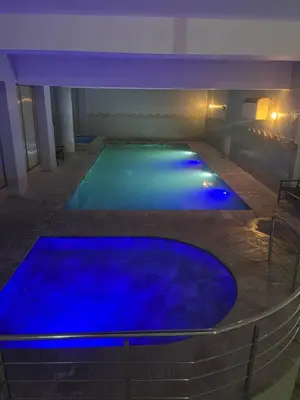 a swimming pool with blue lights in a building at Guéliz Bright apartment with pools in Marrakech