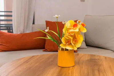 a vase filled with yellow flowers on a table at Appartement Plaza Madani in Marrakech