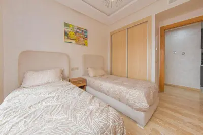 a bedroom with a bed and a dresser in it at Appartement Plaza Madani in Marrakech