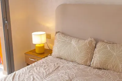 a bedroom with a bed with a lamp on a night stand at Appartement Plaza Madani in Marrakech