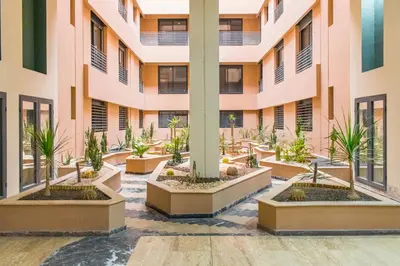 an empty courtyard of a building with potted plants at Appartement Plaza Madani in Marrakech