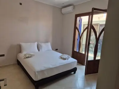 a bedroom with a bed with white sheets and a window at Villa Kaina in Marrakech