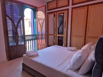a bedroom with a white bed and a balcony at Villa Kaina in Marrakech