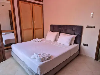 a bed with white sheets and two towels on it at Villa Kaina in Marrakech