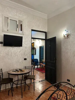 a living room with a table and chairs and a door at Dar Daroune in Marrakech