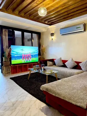 a living room with a couch and a large screen tv at Happy House 2 in Marrakech