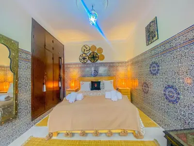 a bedroom with a large bed in a room with tiles at Dar AINA in Marrakech