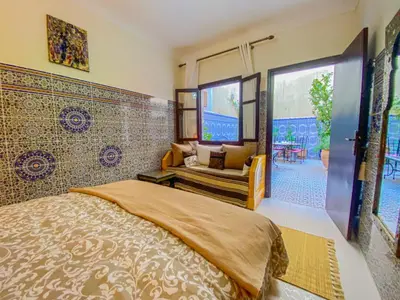 a bedroom with a bed and a couch in it at Dar AINA in Marrakech