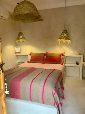 a bedroom with a large bed with red pillows at Dar Tiegezh in Marrakech