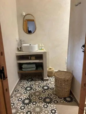 a bathroom with a sink and a mirror at Dar Tiegezh in Marrakech