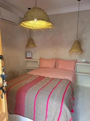 a bedroom with a bed and two pendant lights at Dar Tiegezh in Marrakech