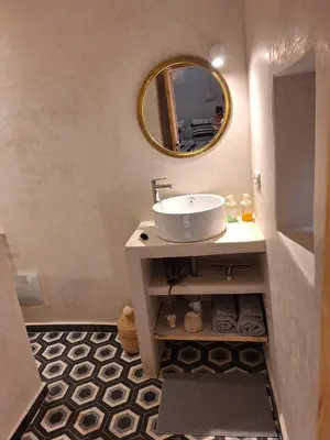 a bathroom with a sink and a mirror at Dar Tiegezh in Marrakech