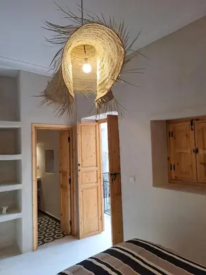 a room with a bed and a chandelier at Dar Tiegezh in Marrakech
