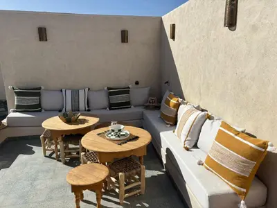 a patio with a couch and tables with pillows at Dar Tiegezh in Marrakech