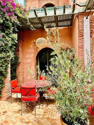 a patio with a table and chairs and flowers at Le Palmito - 2BDR - Private Garden - Pool in Marrakech