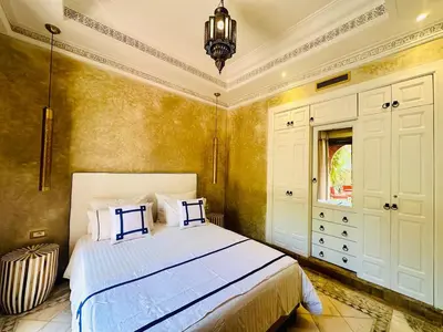a bedroom with a bed and a chandelier at Le Palmito - 2BDR - Private Garden - Pool in Marrakech